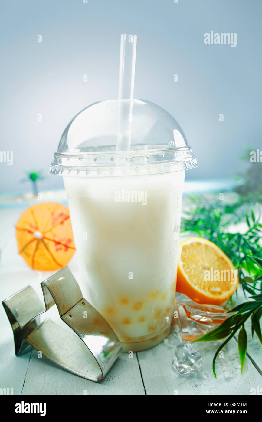 Bolla lattea tè miscelati con fresca frutta arancione e boba o sfere di tapioca servita presso il mare Foto Stock