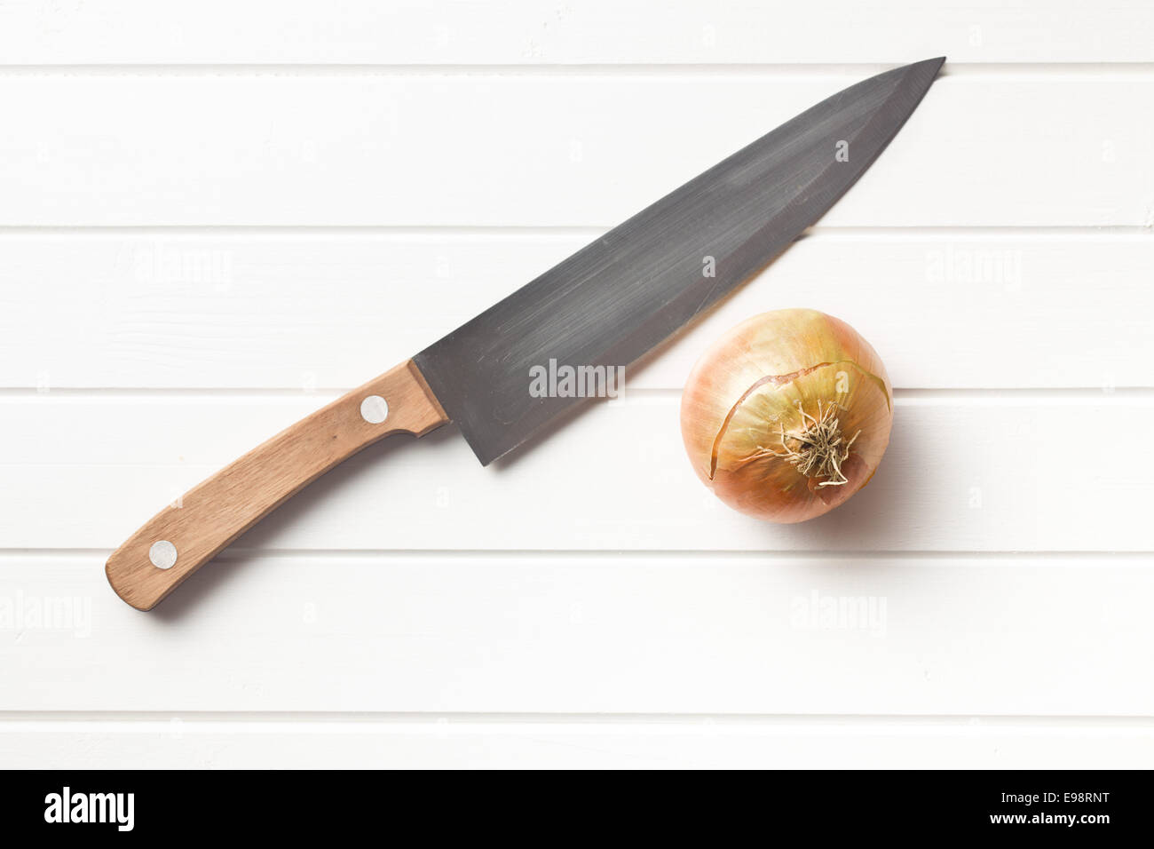 La cipolla e il coltello su bianco tavolo in legno Foto Stock