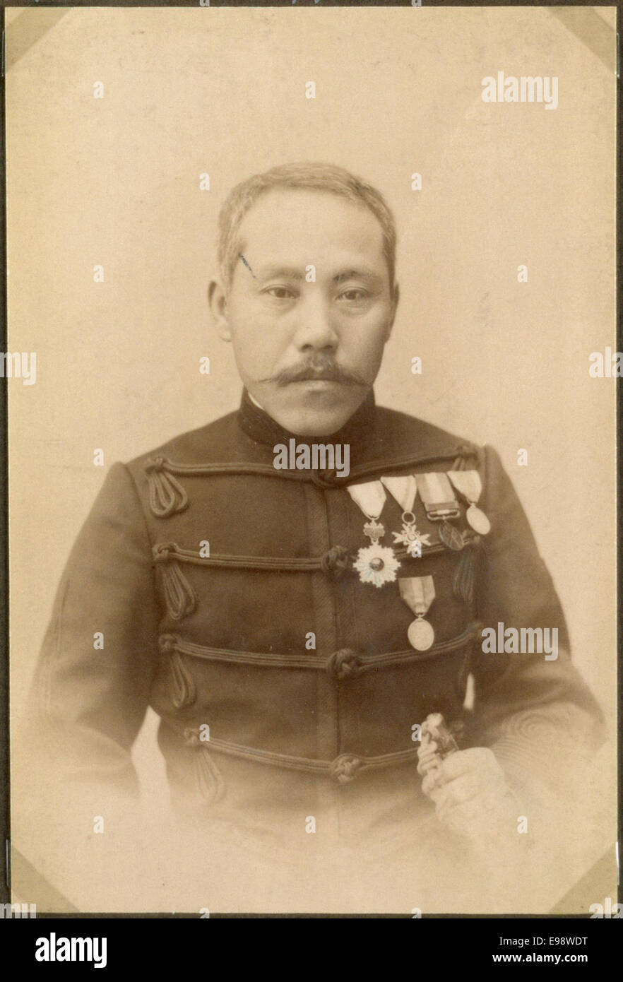 Questa fotografia d'epoca raffigura un ufficiale giapponese in uniforme, probabilmente dell'inizio del XX secolo, che rappresenta l'abbigliamento militare indossato durante il periodo in Giappone, mostrando il design dettagliato dell'uniforme. Foto Stock