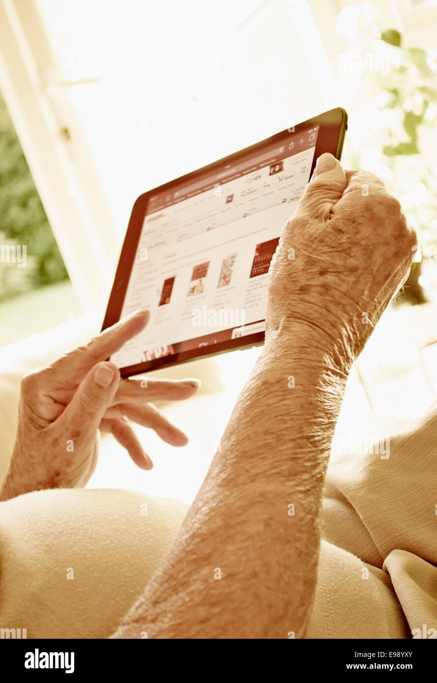 Senior persona mani usando un computer tablet. Foto Stock
