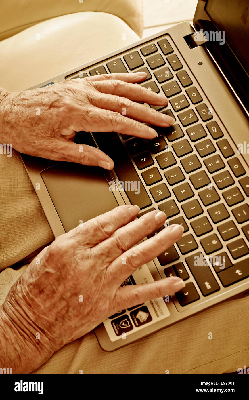 Senior persona con le mani in mano utilizzando un computer portatile. Foto Stock