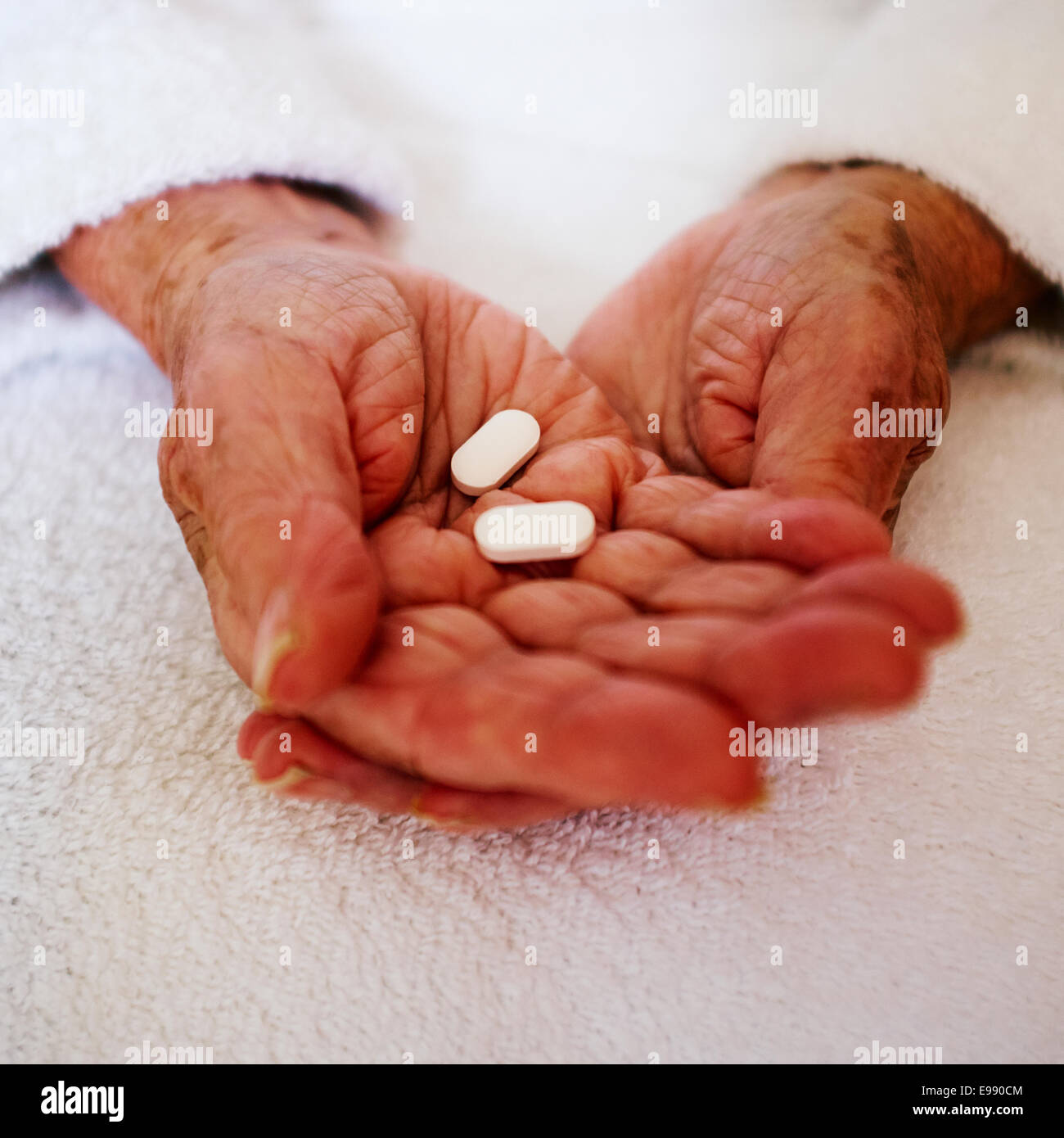 Senior persona con le mani in mano azienda pillola bianco / tablet di prescrizione farmaci - assistenza sociale. Foto Stock