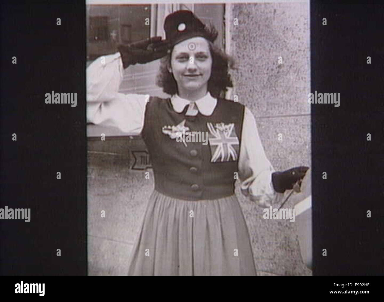 Una fotografia di una donna che indossa i distintivi della RAF e tiene in mano il Dannebrog, la bandiera danese. Questa immagine rappresenta probabilmente la sua associazione con la Royal Air Force e la sua eredità danese. Foto Stock