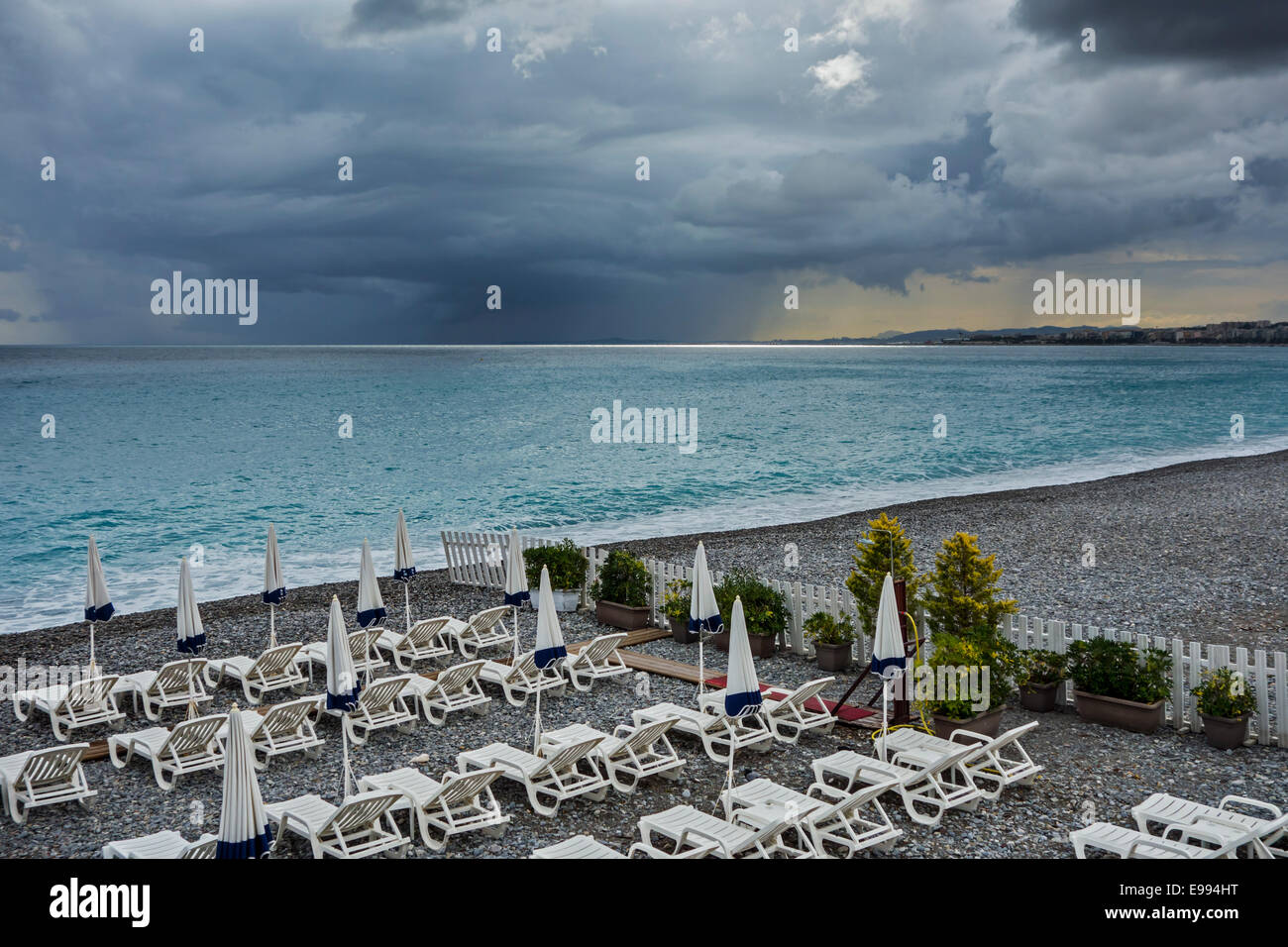 White sdraio sulla spiaggia deserta durante il maltempo con scuri, minacciano pioggia nuvole sul mare Foto Stock