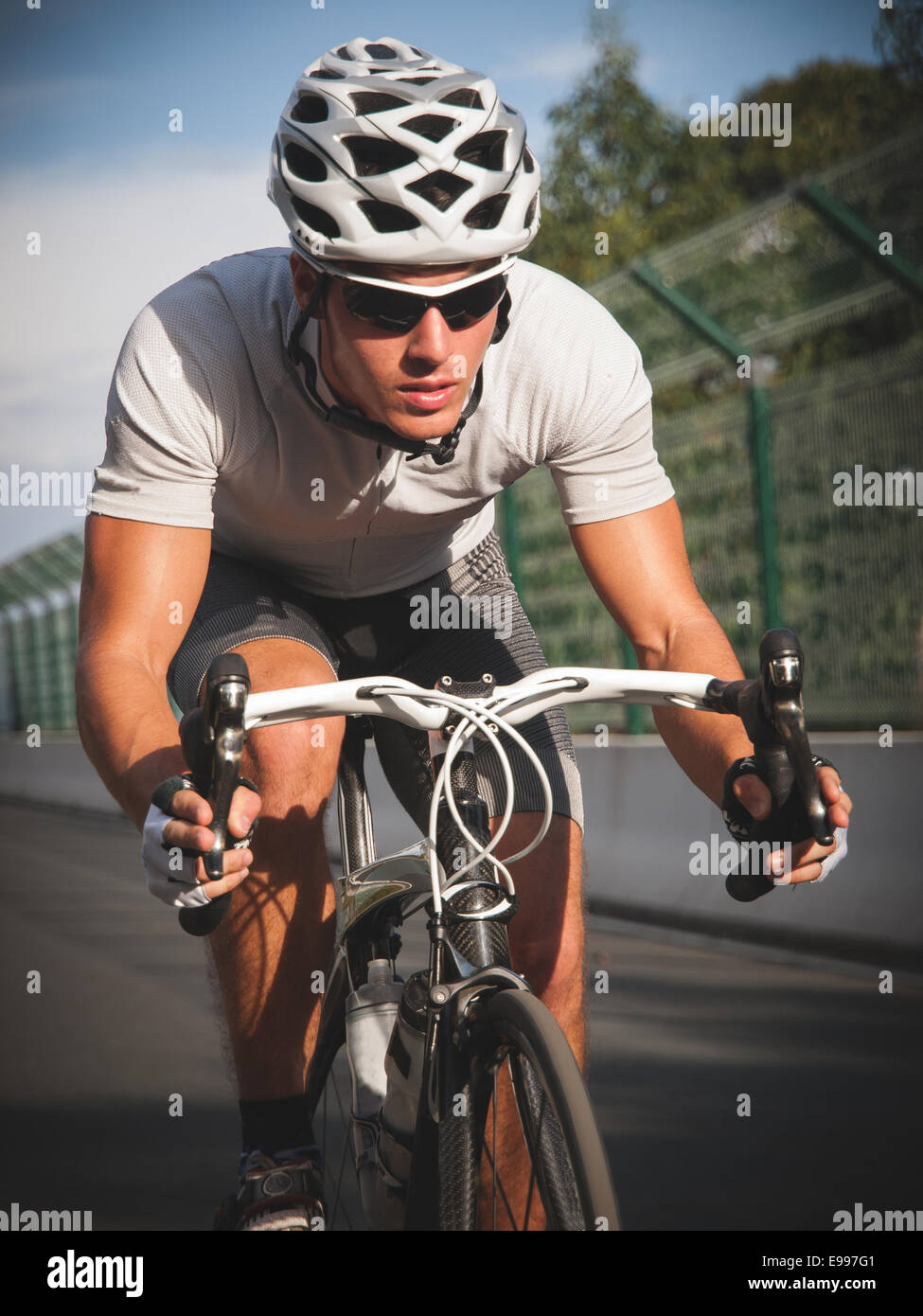Ciclista ritratto in azione sulla strada in una giornata di sole. Foto Stock