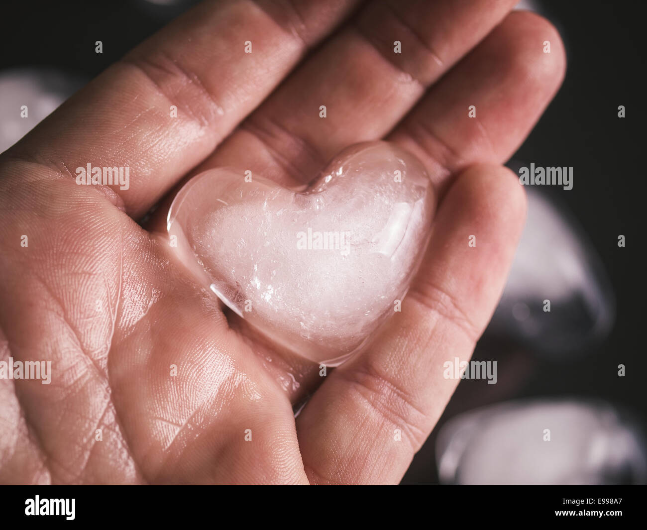 Cuore di ghiaccio in una mano in una extreme close up foto. Foto Stock