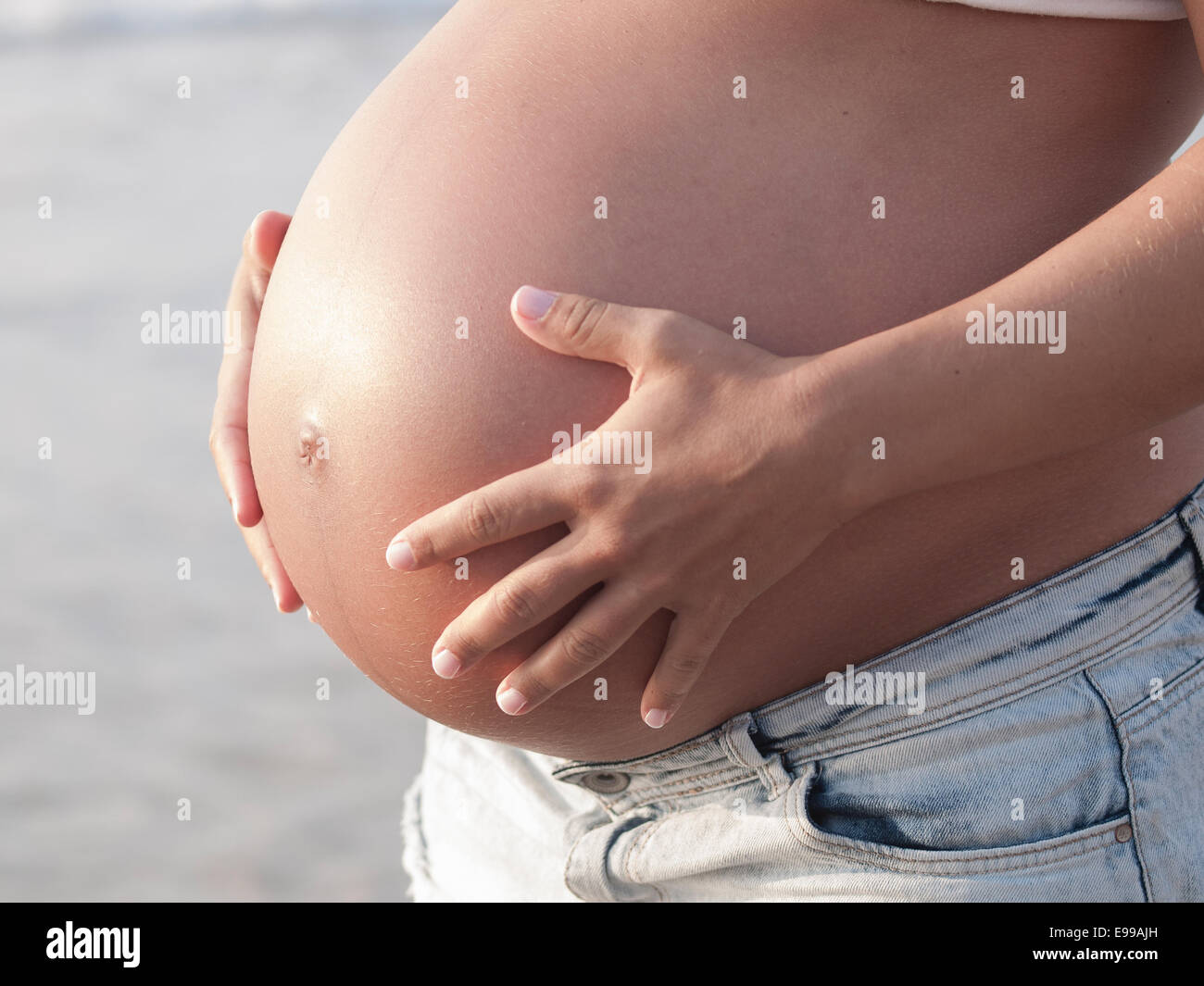 Gravidanza dettaglio del ventre di una donna in esterno Foto Stock