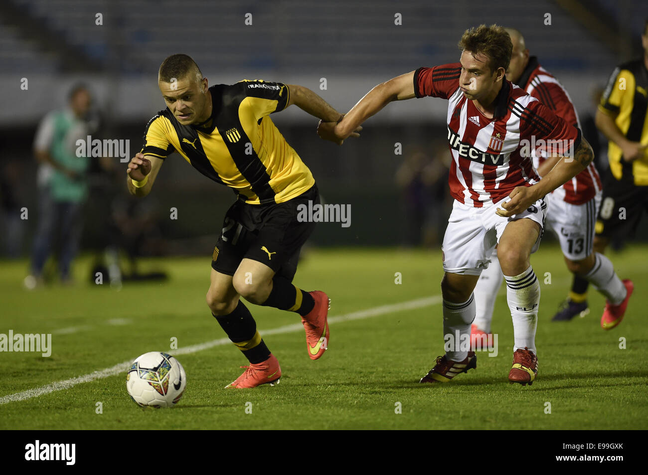 Montevideo, Uruguay. 22 ottobre, 2014. Jonathan Rodriguez (L) del Penarol il sistema VIES per la palla con Gaston Gil Romero di Estudiantes De La Plata durante il loro turno di 16 match della South American Cup presso lo stadio del Centenario di Montevideo, capitale dell'Uruguay, su Ott. 22, 2014. Credito: Nicolas Celaya/Xinhua/Alamy Live News Foto Stock