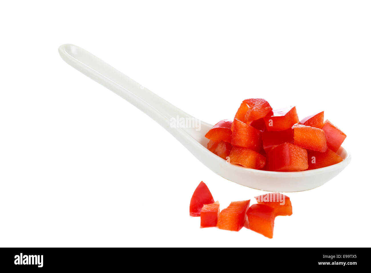 Peperoni rossi tritati in cucchiaio bianco isolato su sfondo bianco Foto Stock