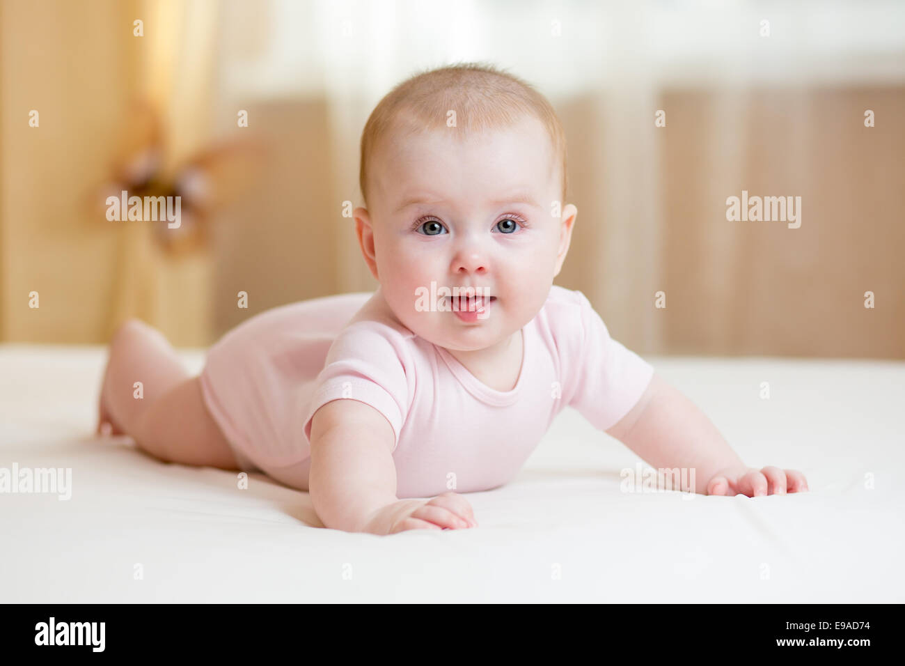 Baby girl giacente sul letto bianco Foto Stock