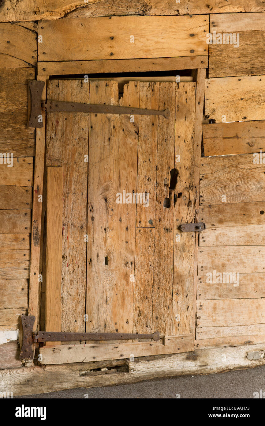 Vecchio legno color miele rustico colorato crooked plancia porta di legno con lunghe cerniere di ferro Foto Stock
