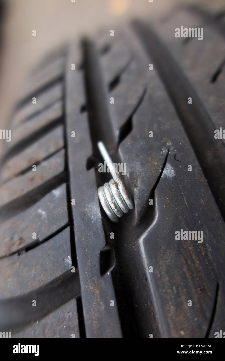 Foratura / forato pneumatico auto / pneumatico con sharp molla (diverso da chiodo o vite) incorporati nel battistrada. Regno Unito Foto Stock