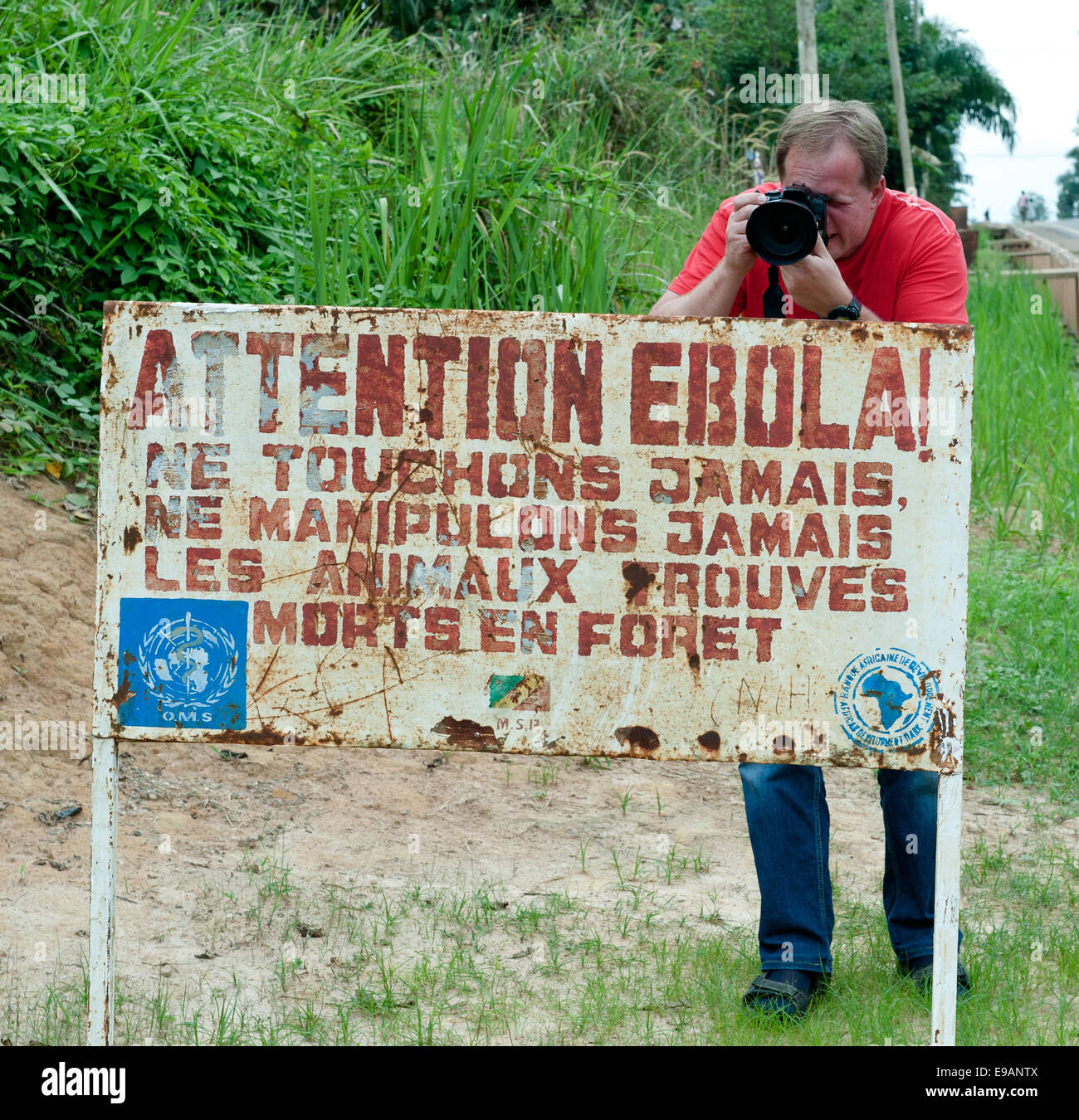 Auto e segno avverte i visitatori che la zona è un virus di Ebola infetti. Foto Stock