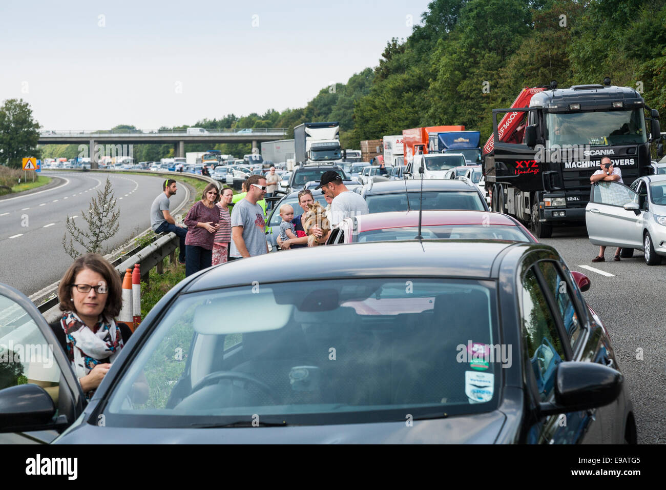 Il traffico a fermo / non si muove a causa di incidente. In attesa driver / passeggeri hanno lasciato auto e veicoli a chiedersi su strada Foto Stock