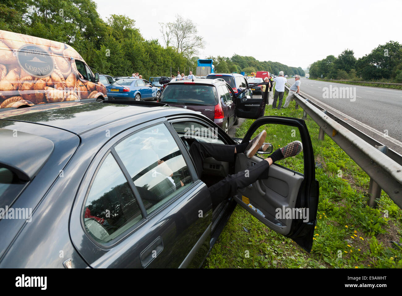 Il traffico a fermo / non si muove a causa di incidente. In attesa driver / passeggeri hanno lasciato auto e veicoli a chiedersi su strada Foto Stock
