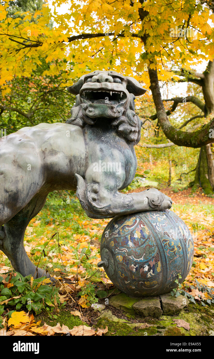 Cinese cane pippo statua in bronzo a Batsford Arboretum in autunno. Moreton-in-Marsh, Gloucestershire, Inghilterra Foto Stock