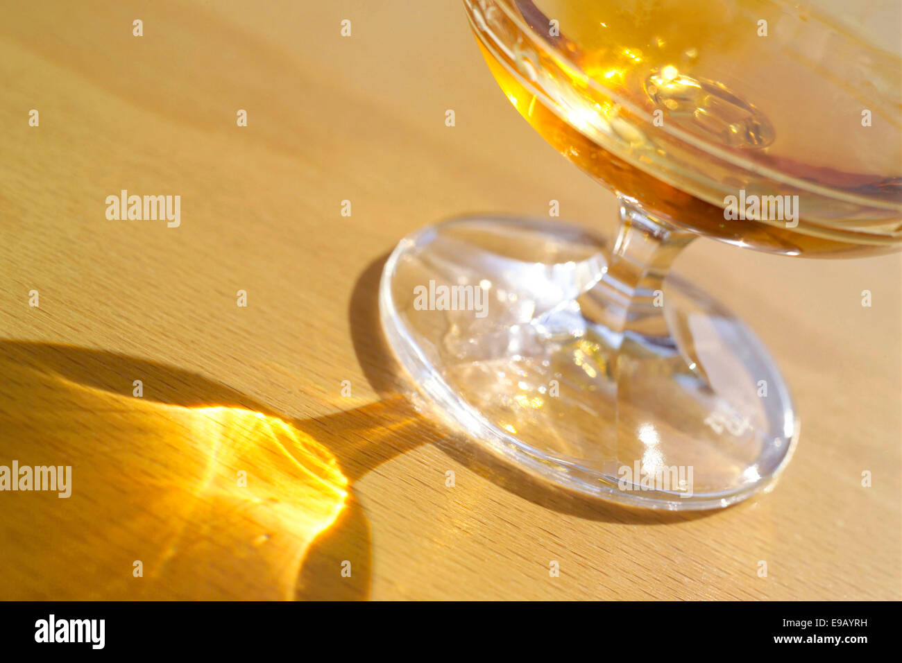 Riempito di vetro Cognac con riflessi sul piano del tavolo Foto Stock