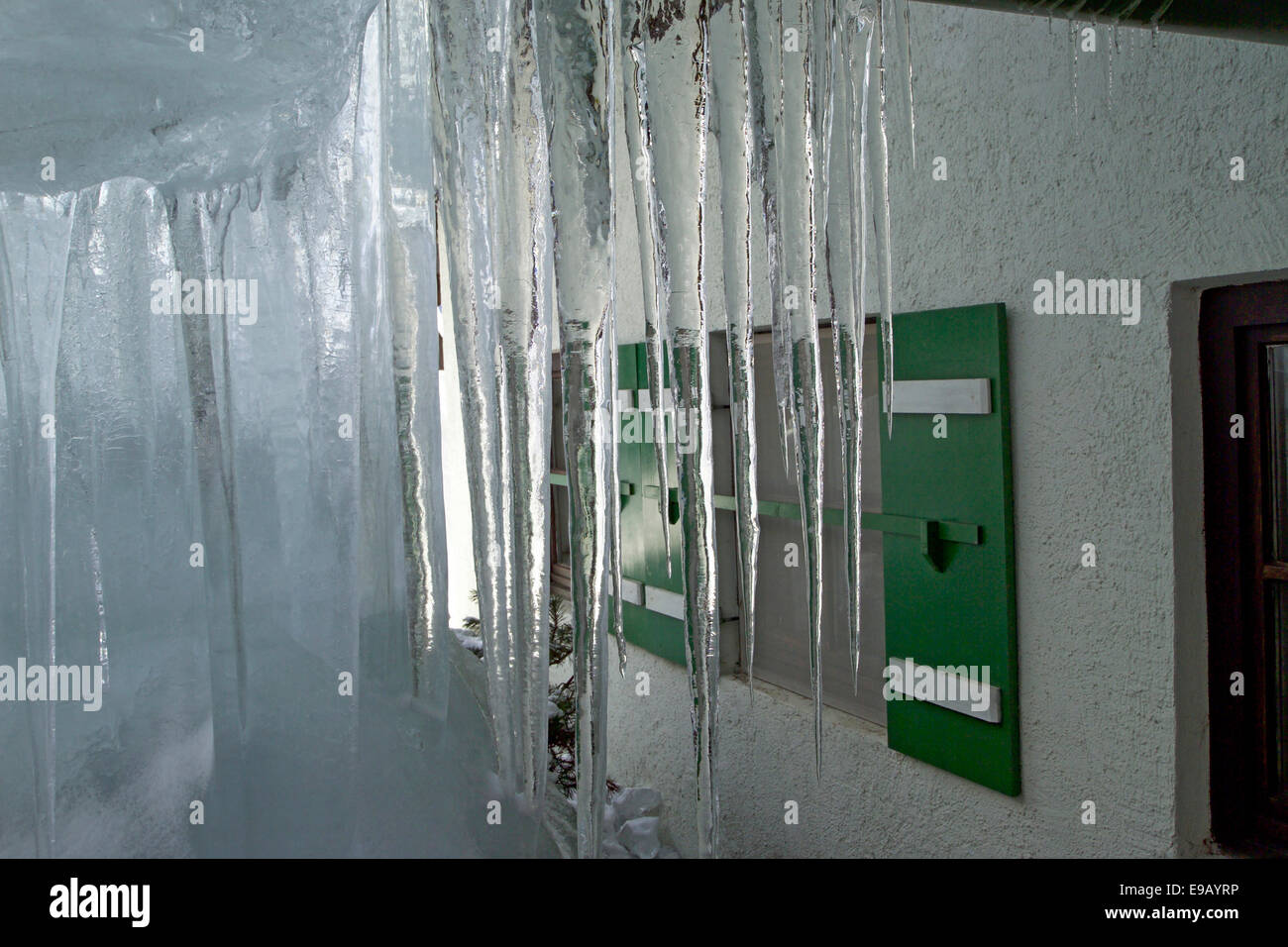 Ghiaccioli su una casa nelle Alpi Foto Stock