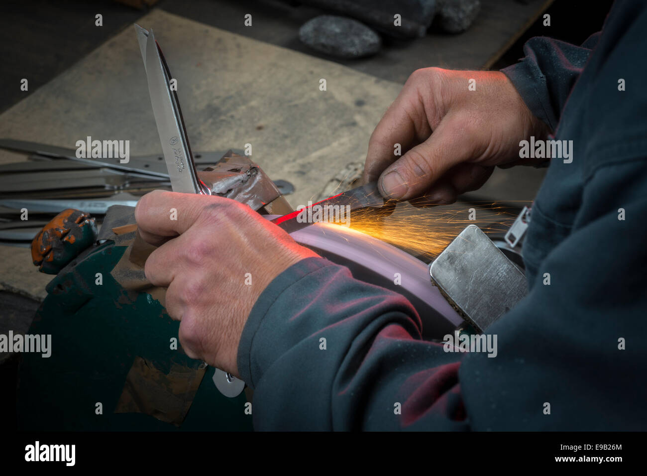 Una fase di realizzazione di un coltello in una Thiers posate opere (Francia). Sharpener - Knifegrinder - arrotino - coltello macinatore Foto Stock