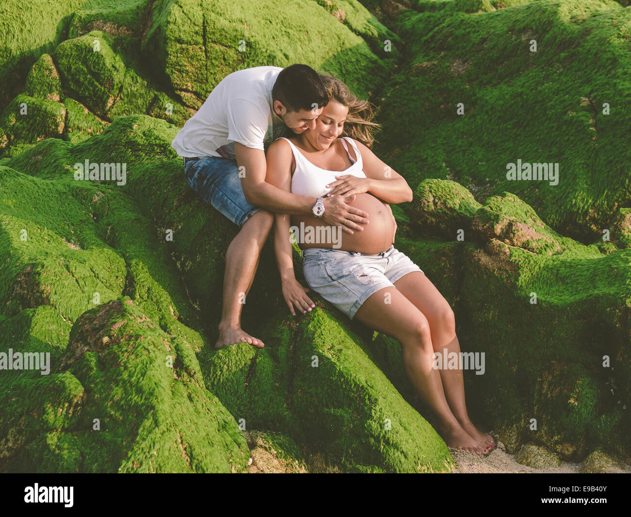 Felice di gravidanza giovane sulla spiaggia all'esterno. Foto Stock