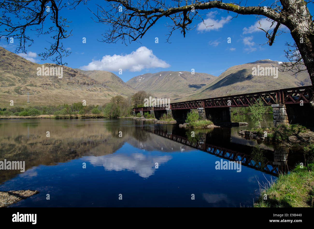Le riflessioni di montagne e ponte ferroviario sul Loch Awe, Highlands scozzesi Foto Stock
