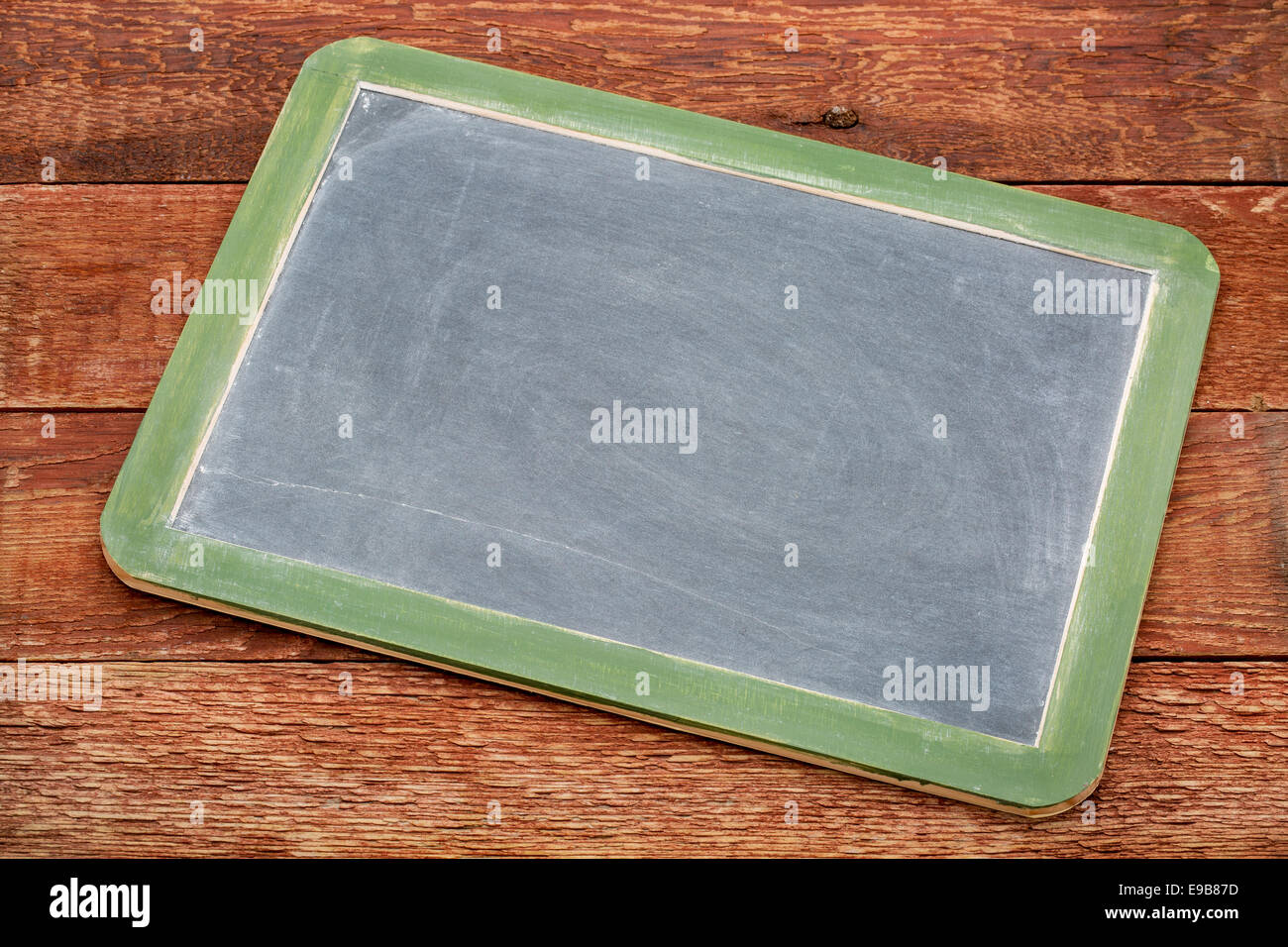 Vuoto lavagna ardesia segno contro weathered dipinta di rosso di legno del granaio Foto Stock