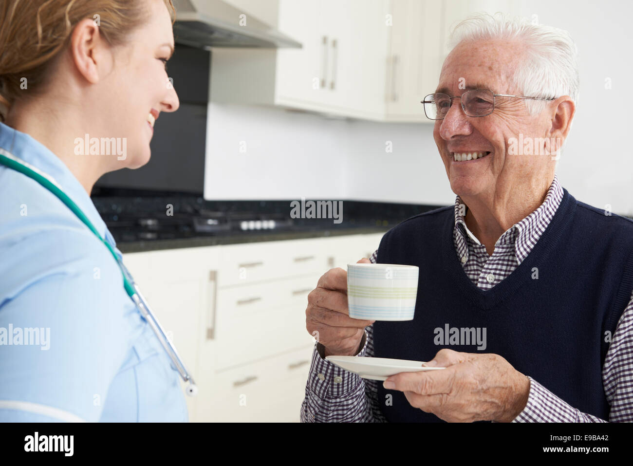 L'infermiera in chat con i Senior uomo durante la visita iniziale Foto Stock