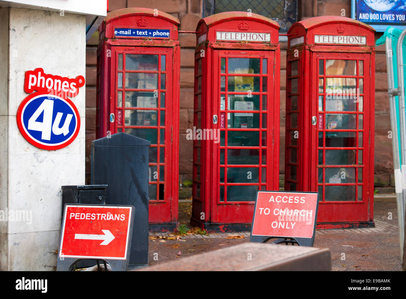Tre K6 BT cabine telefoniche in Bridge Street, Warrington vicino a telefoni cellulari 4U Shop, UK  pedonale segno di diversione. Foto Stock