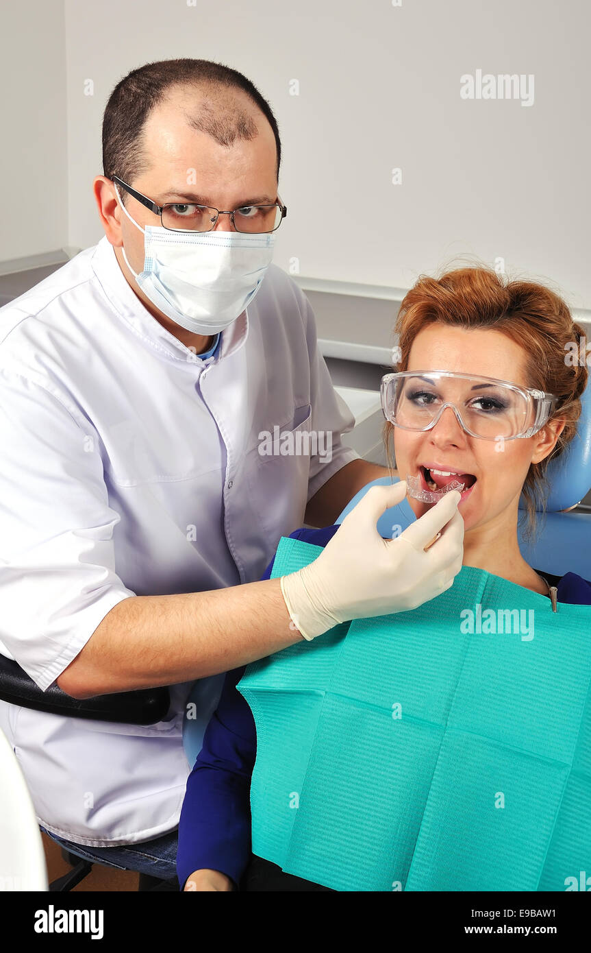 Dentista cerca fissatore dentale ragazza giovane Foto Stock