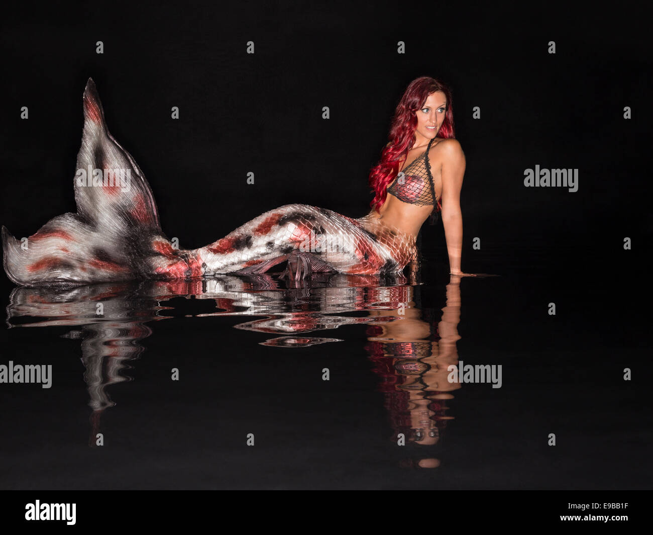 Redhead mermaid in una piscina a specchio in Virginia Beach, Virginia Foto Stock