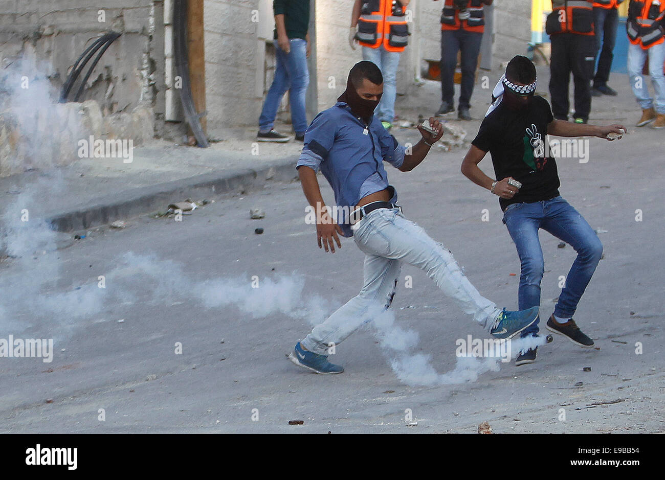 Gerusalemme. 23 ott 2014. Un palestinese protestor calci una bomboletta di gas sparati dalla polizia israeliana durante scontri nella Gerusalemme est quartiere di Issawiya, Ottobre 23, 2014. La tensione in Gerusalemme luogo mercoledì dopo un israeliano bambino morto e altre otto persone sono state ferite quando un uomo palestinese ha sbattuto la sua auto nel pedoni a Gerusalemme light railway stop. Polizia ha sparato il conducente come egli fuggì. Un ospedale funzionario detto il driver più tardi morì di ferite. © Muammar Awad/Xinhua/Alamy Live News Foto Stock