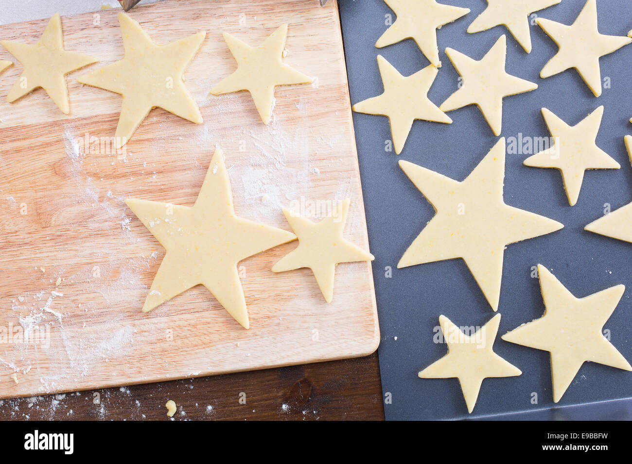 A forma di stella di Natale pasta biscotto sul tagliere e la teglia dal di sopra. Foto Stock