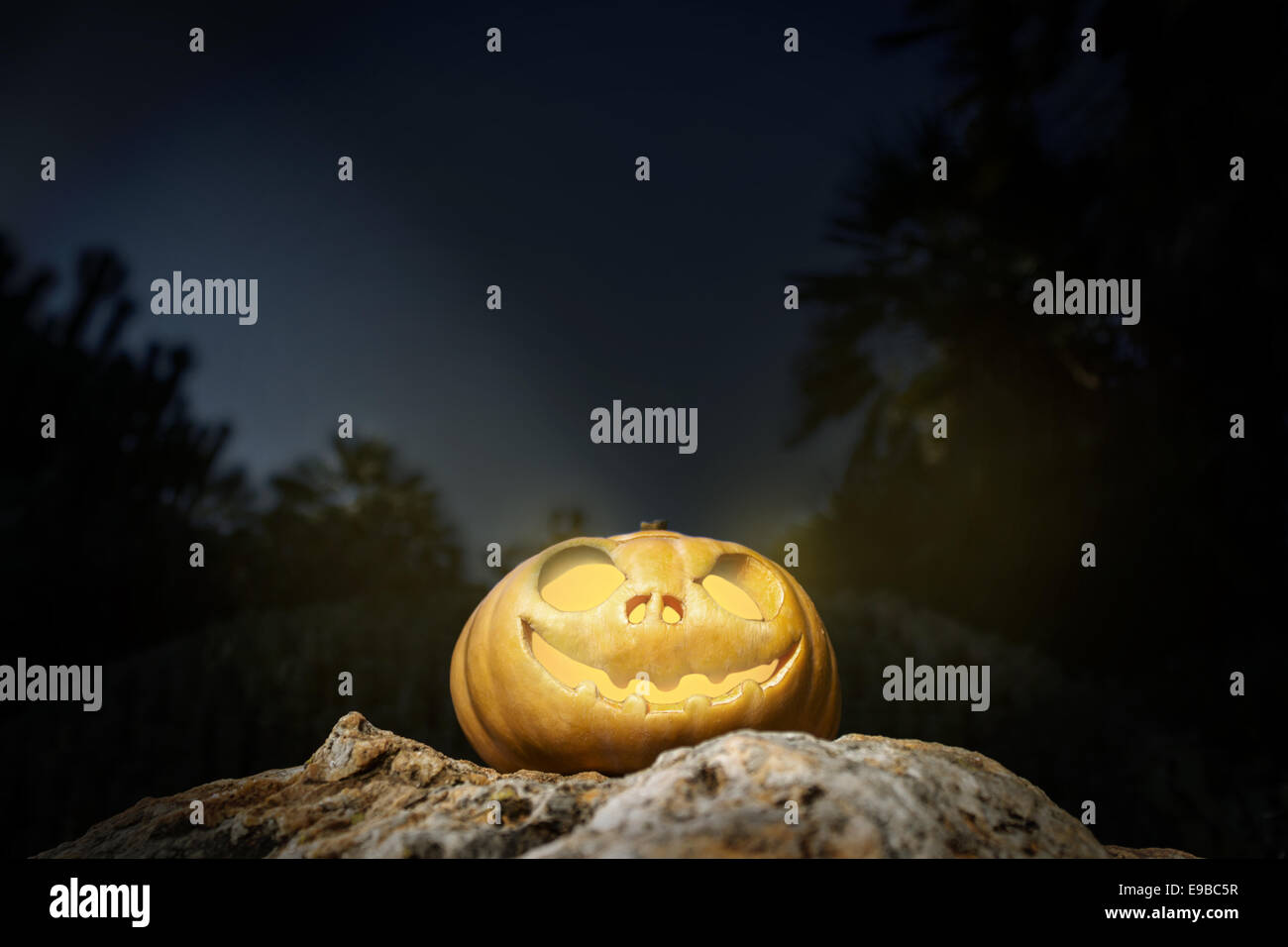 Scary Halloween zucca jack-o-lantern con un sorriso su una roccia dalla prospettiva di fondo illustrazione del modello dal buio Foto Stock