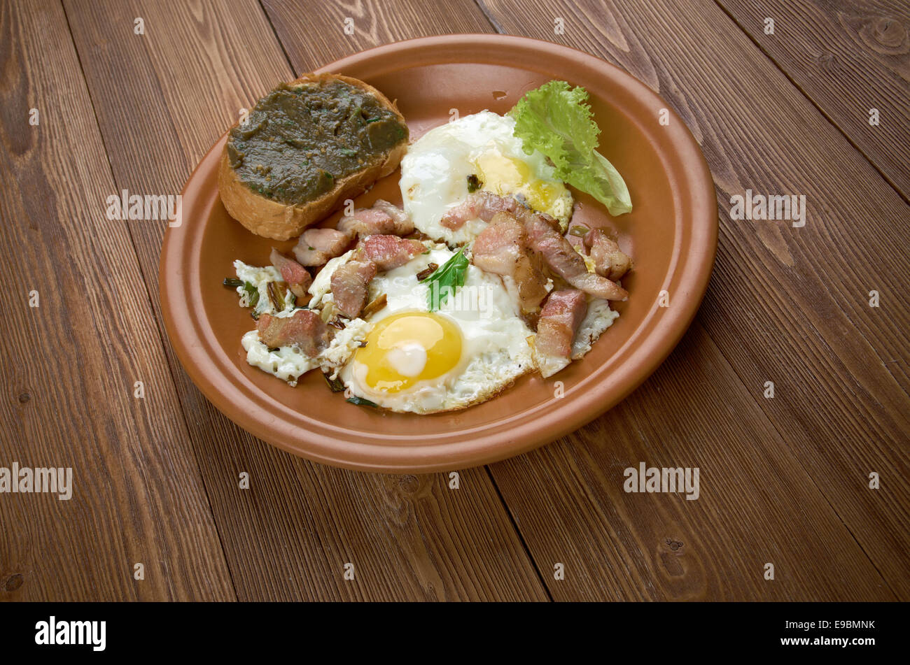 Paese europeo prima colazione - uova fritte, pancetta fritta e baguette con melanzana pasting Foto Stock