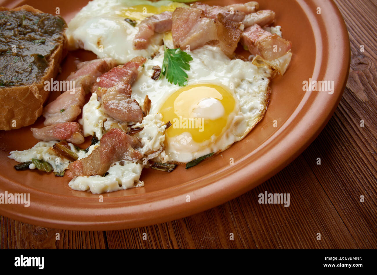 Paese europeo prima colazione - uova fritte, pancetta fritta e baguette con melanzana pasting Foto Stock