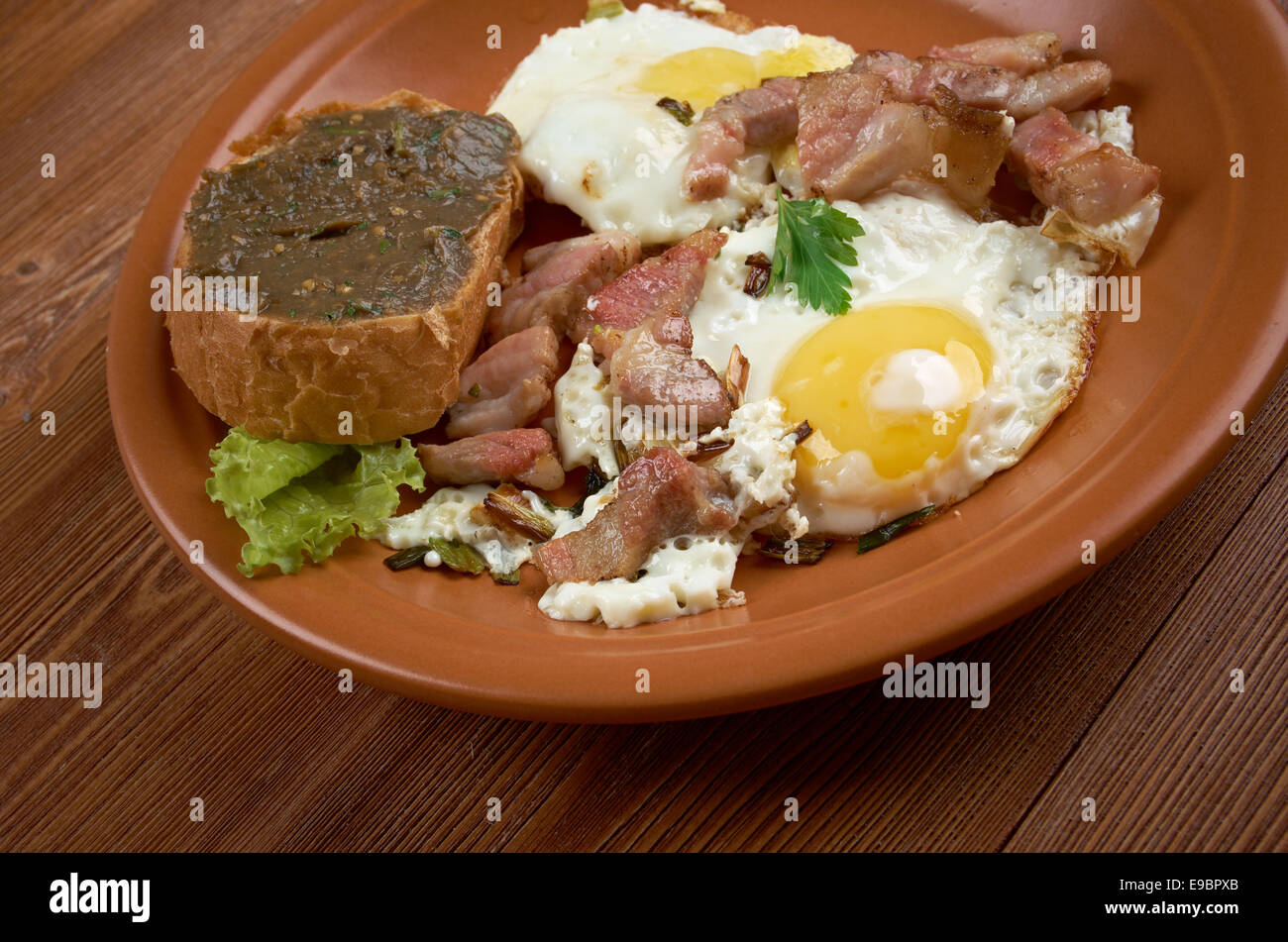 Paese europeo prima colazione - uova fritte, pancetta fritta e baguette con melanzana pasting Foto Stock