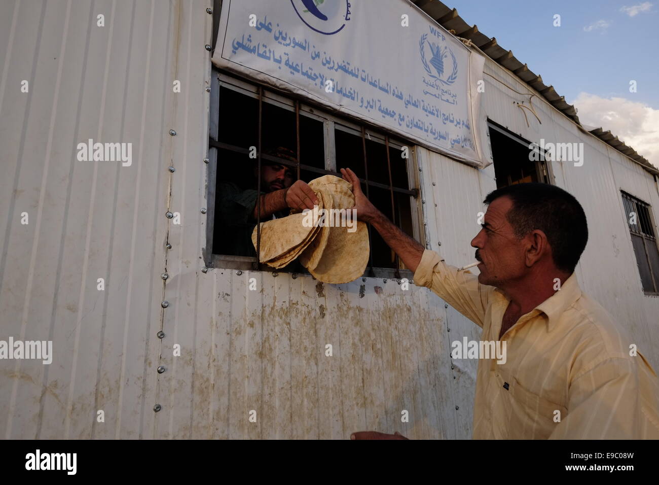 Un uomo di Yazidi riceve pane piatto donato dal programma alimentare Mondiale delle Nazioni Unite WFP al campo profughi di Nawroz, inizialmente istituito per proteggere i siriani sfollati dalla guerra civile siriana in corso, poi occupati da sfollati della minoranza Yazidi setta, In fuga dalla violenza nella città irachena di Sinjar situata vicino alla città di al-Malikyah nella regione autonoma curda di Rojava, Siria nord-orientale. Foto Stock