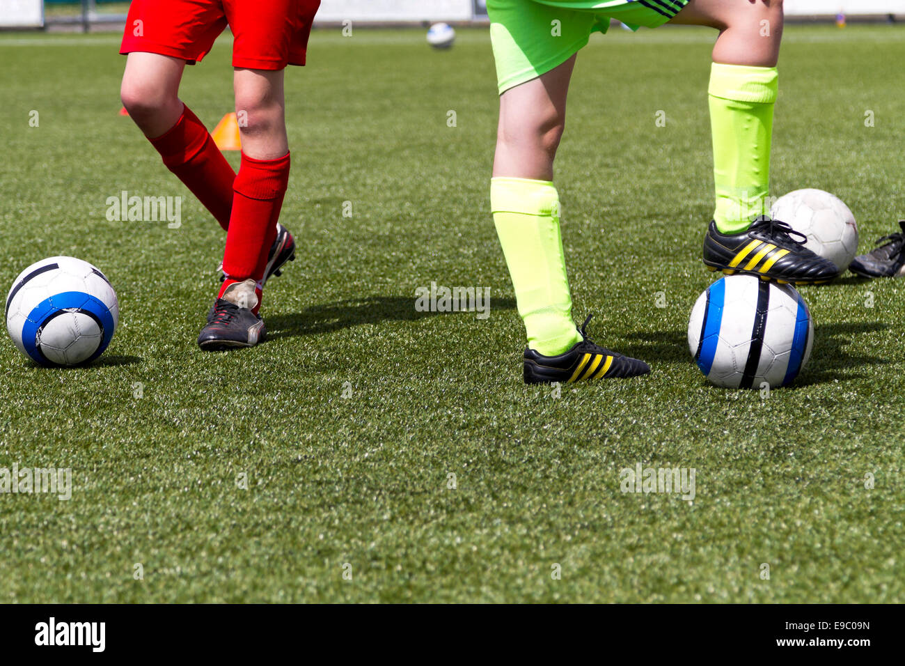 Due giovani giocatori di calcio a una sessione di formazione vestito di rosso e verde Foto Stock