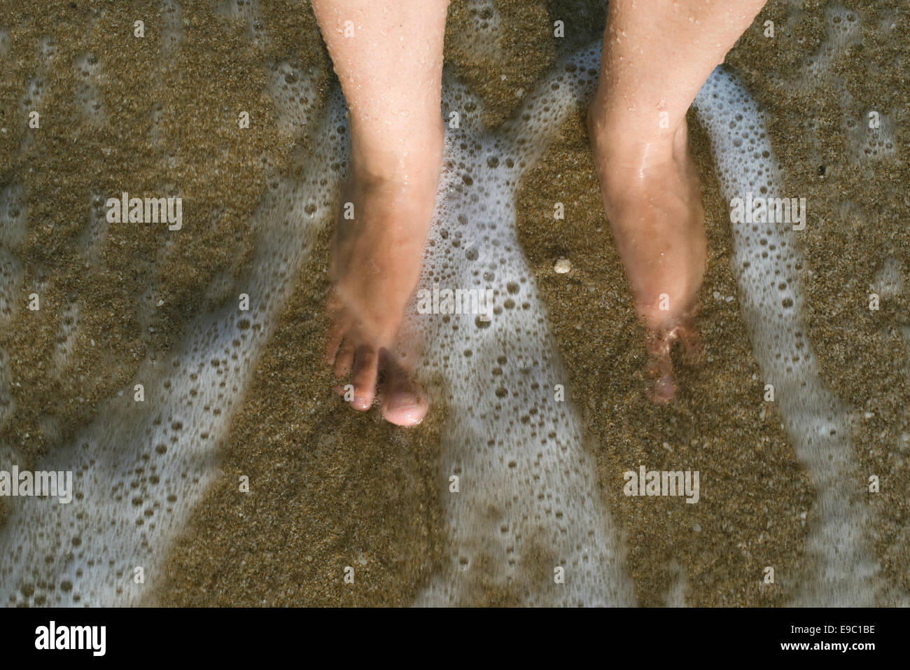Due gambe in onde del mare. Suny giorno Foto Stock