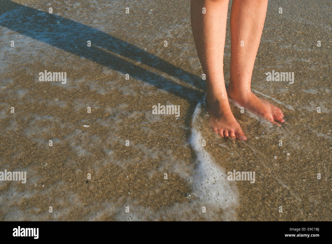 Due gambe in onde del mare. Suny giorno Foto Stock