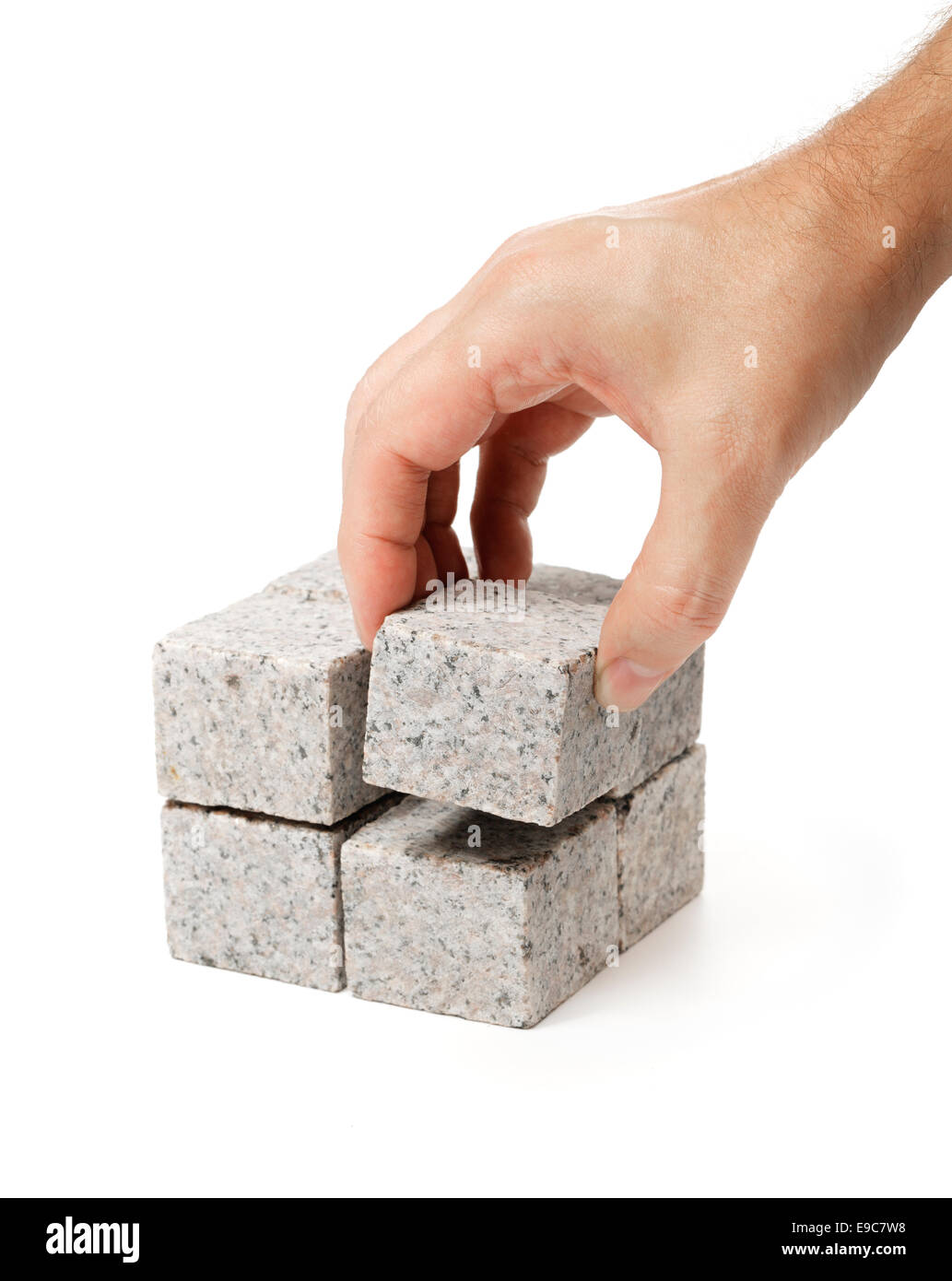 L'uomo costruire un cubo di cubi più piccoli fatti di roccia di granito. Foto Stock