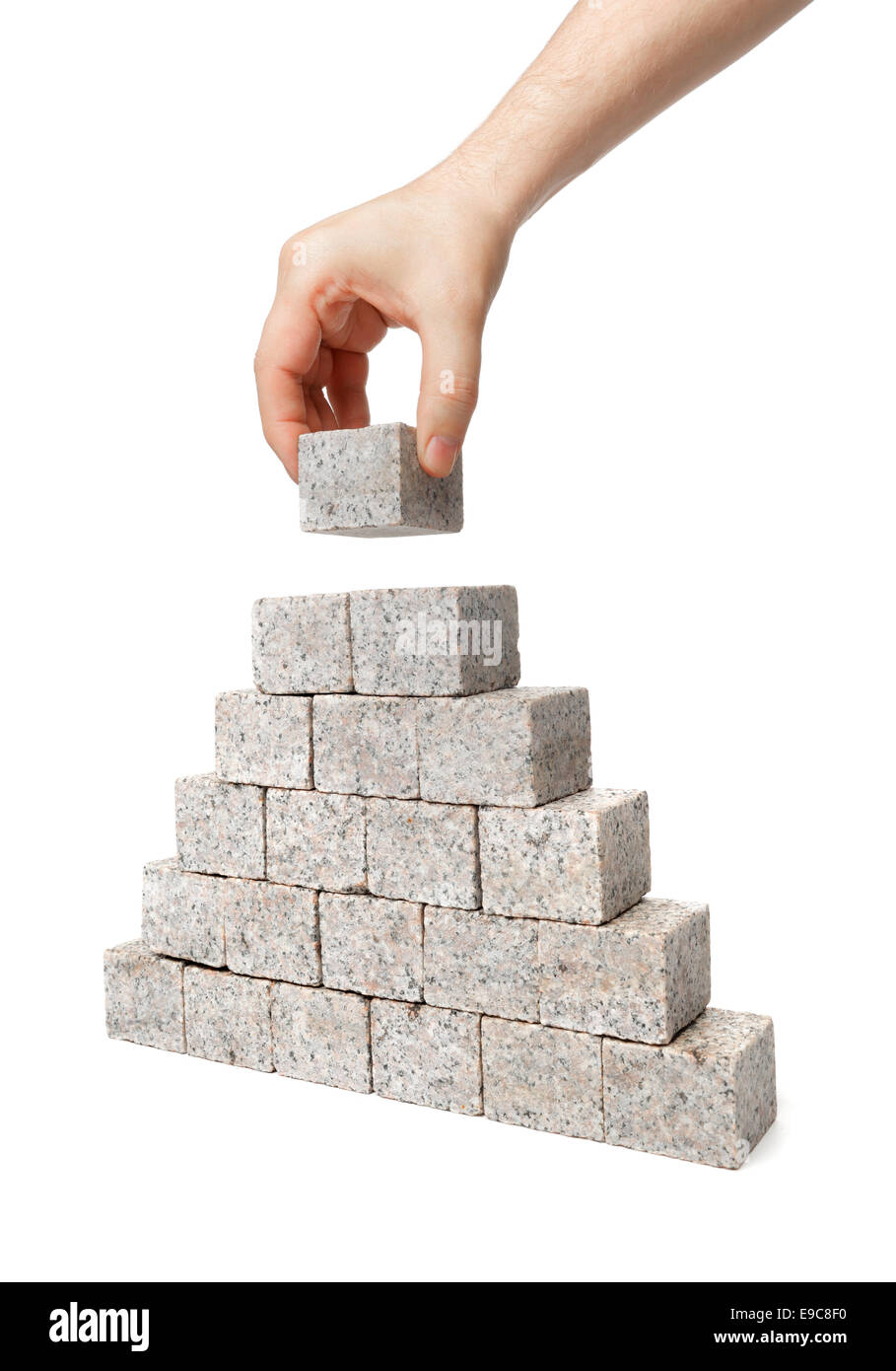 L'uomo costruire la piramide fatta di piccoli blocchi di roccia di granito. Foto Stock