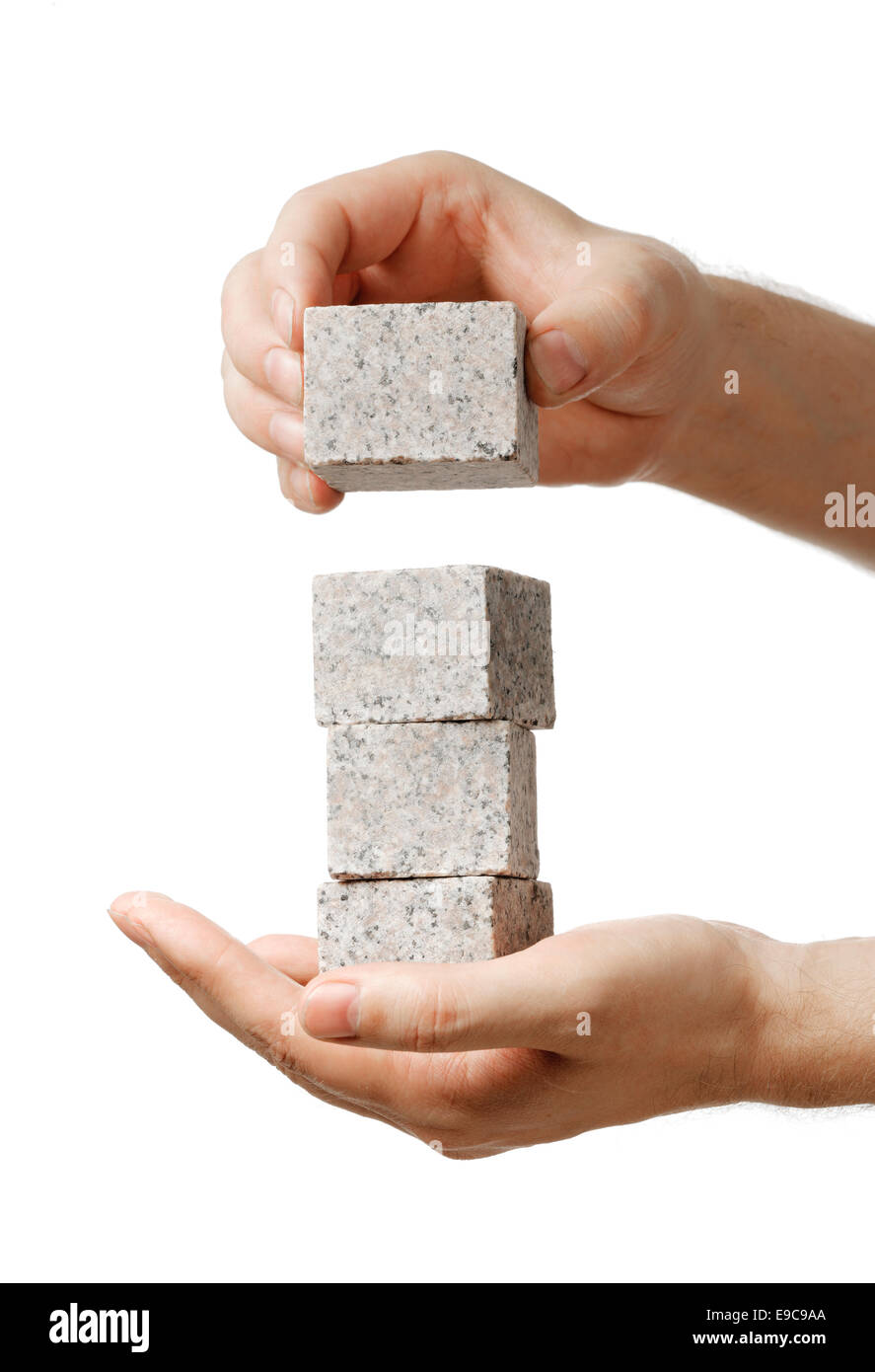 Impilatura di uomo di piccoli blocchi di roccia di granito nelle sue mani. Foto Stock