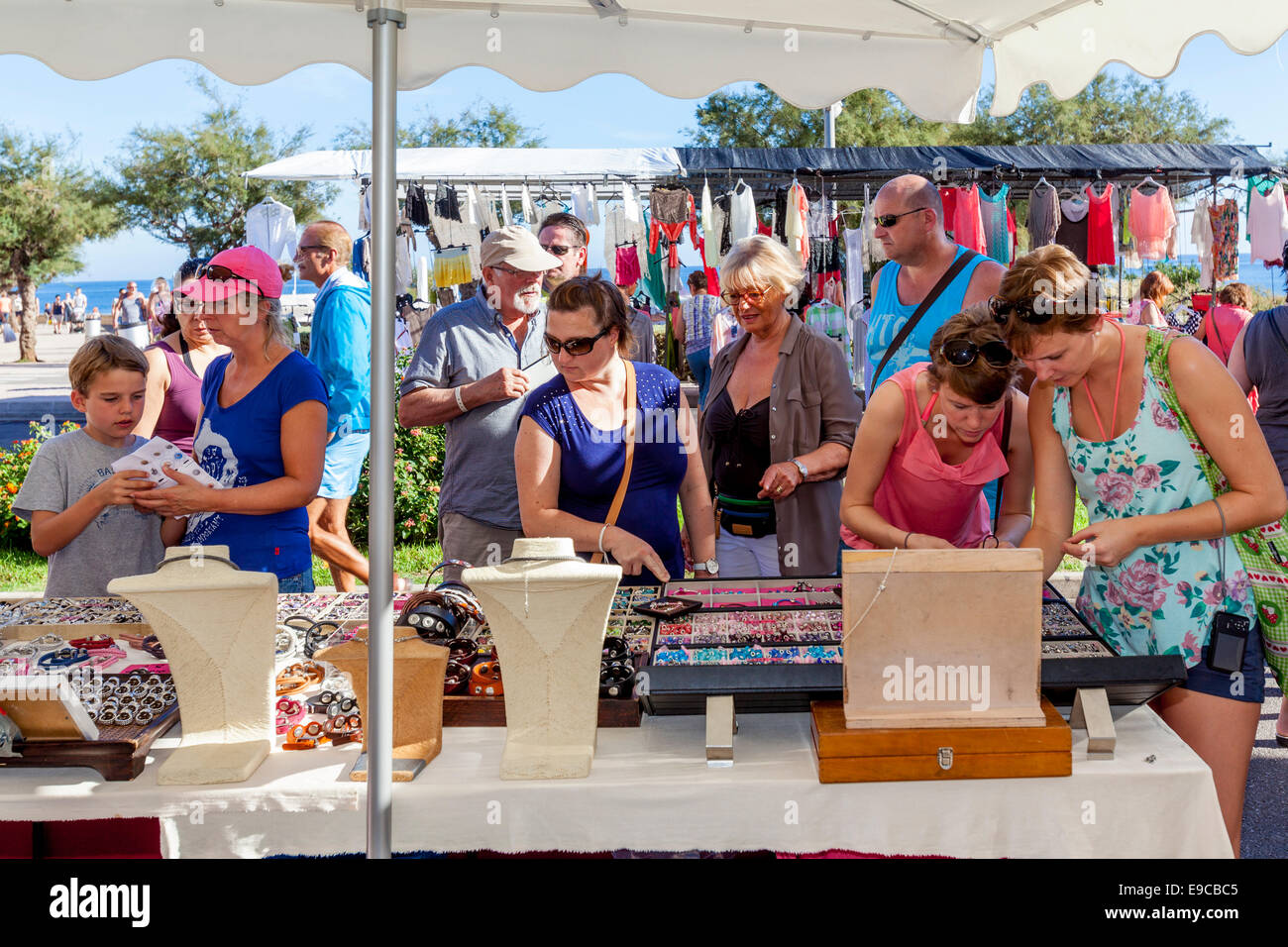 I turisti dello Shopping di gioielli e bracciali presso il mercato del venerdì a Ca'n Picafort, Maiorca - Spagna Foto Stock