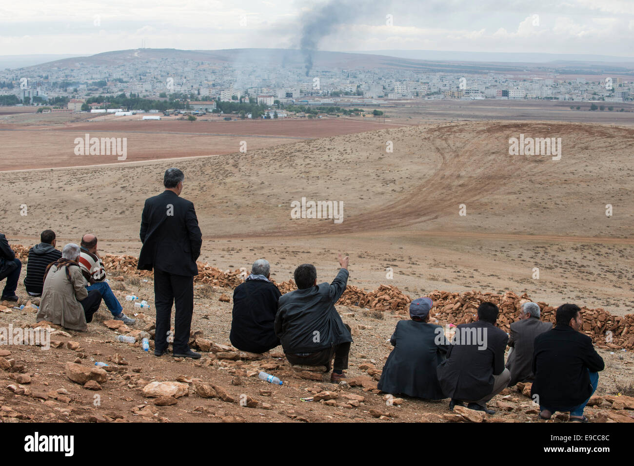 Turchia, Suruc,10 km dalla frontiera siriana e da è stato islamico assediata città Kobani, Curdi guardare la battaglia in Kobane dalla montagna, fumo in salita dopo il bombardamento da parte di noi airforce Foto Stock