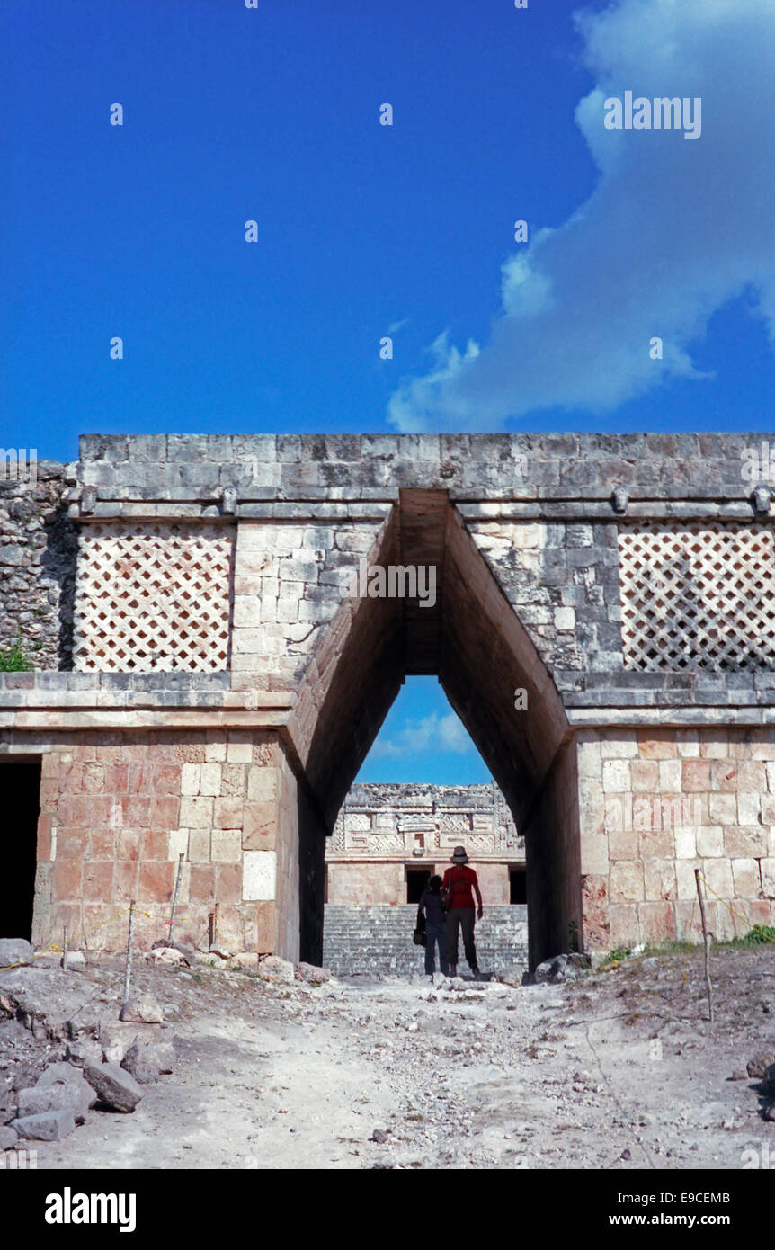 Due donne in piedi sotto un corbeled Maya arch nel Monastero un quadrangolo Uxmal, Yucatan, Messico Foto Stock