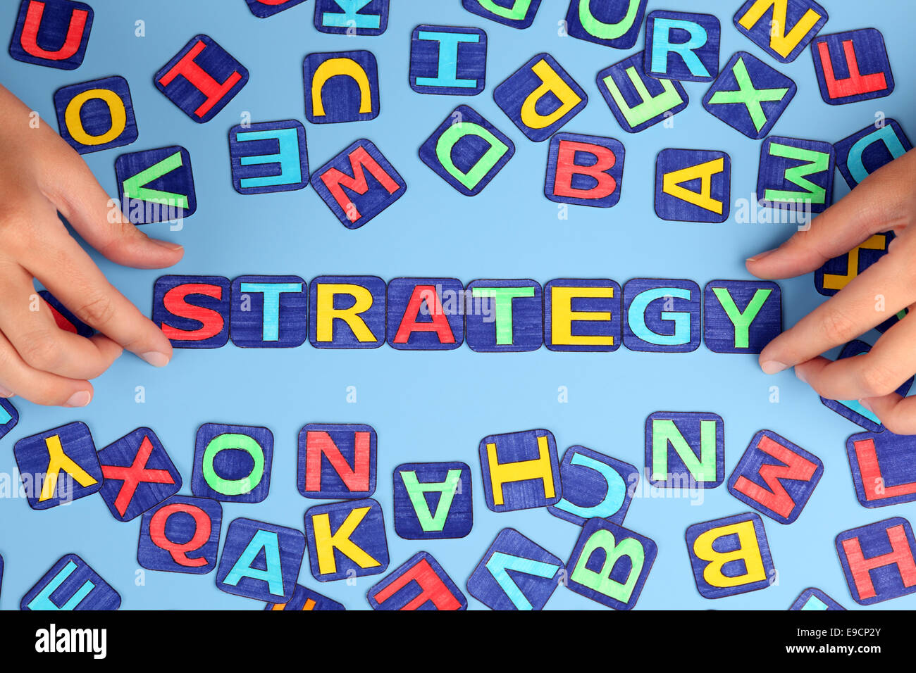 La parola "strategia" scrivi su sfondo blu con la donna con le mani in mano e lettere. Lettere disegnati da me. Foto Stock