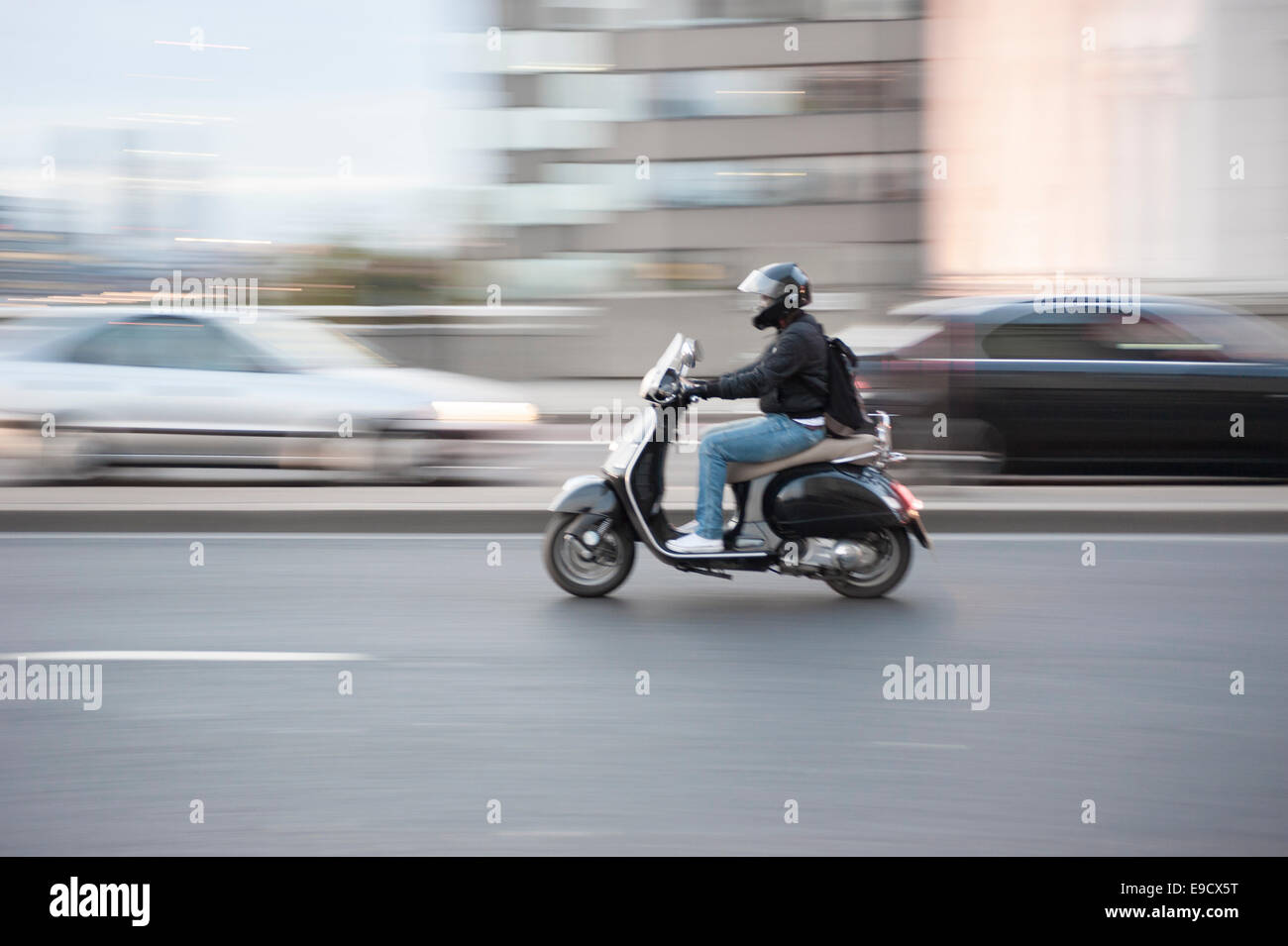 Un uomo su uno scooter con motion blur, London, Regno Unito Foto Stock