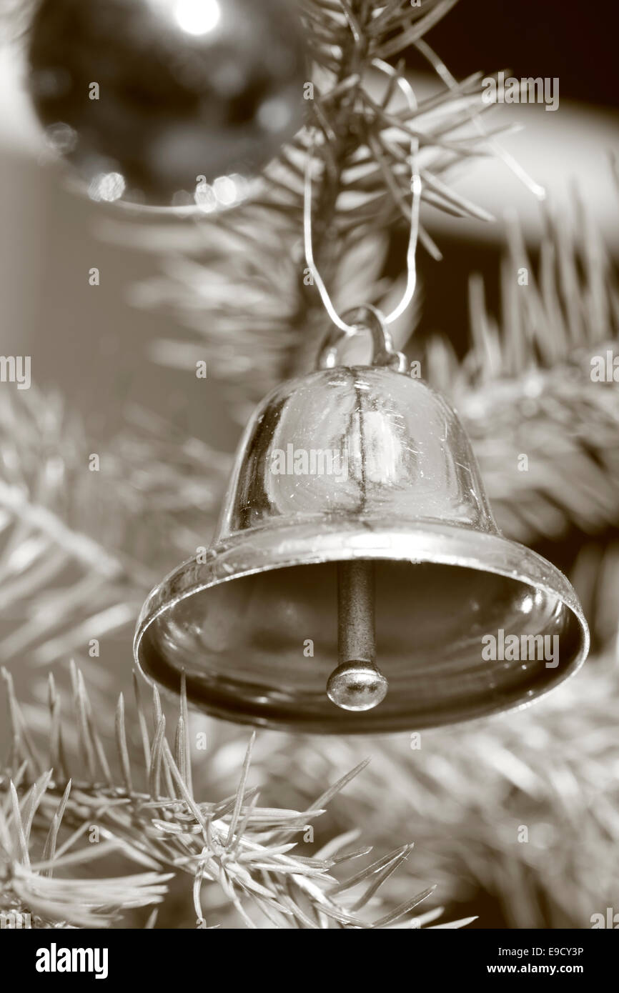 Una campana è appeso a un albero di Natale. Fotografia in bianco e nero, seppia oscurata. Foto Stock