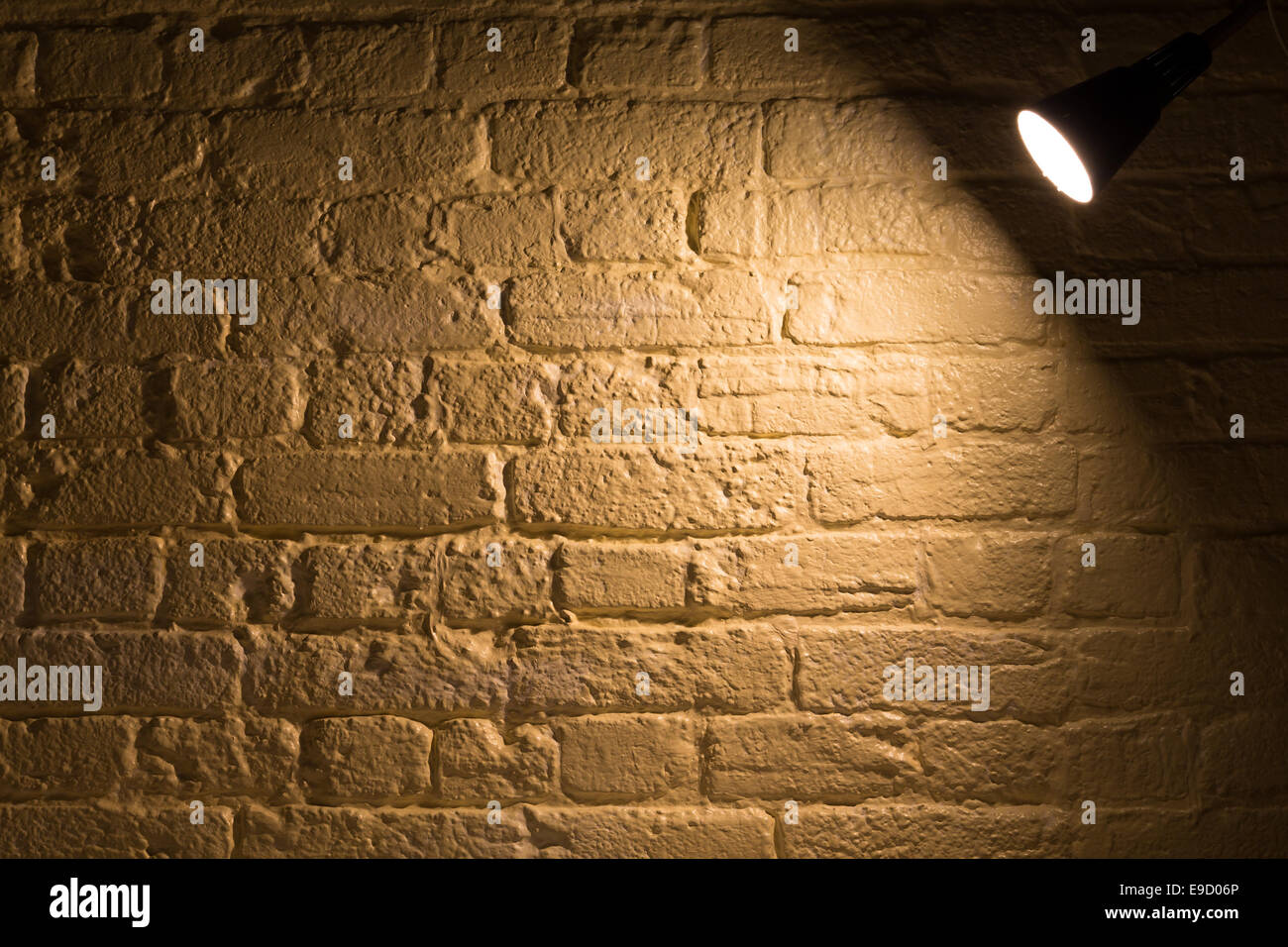 Una lampada incandescente al buio su un muro di mattoni. Uno sfondo, un  muro di mattoni texture con una lampada. Spazio di copia Foto stock - Alamy